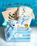 Baby gift basket with blue teddy bear, books, and toys against a blue background with text.