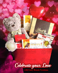 A Valentine's Day themed gift basket containing a plush teddy bear, chocolates, and cookies, with 'Celebrate Your Love' text and the logo of Cute Beauty Creations.